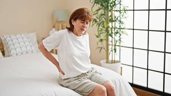 Orta Yaşlı Bir Kadın Sırt Ağrısı Çekiyor Yatak Odasında Oturuyor — Stok fotoğraf