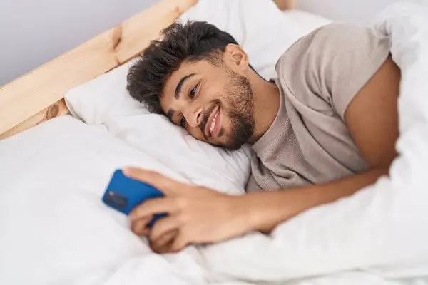 Hombre Árabe Joven Usando Teléfono Inteligente Acostado Cama Dormitorio —  Fotos de Stock