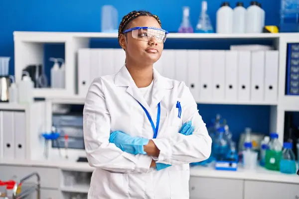 African american woman scientist standing with arms crossed gesture at laboratory