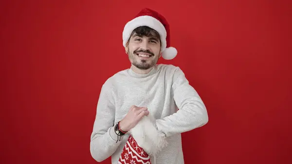 Νεαρός Ισπανός Που Φοράει Χριστουγεννιάτικο Καπέλο Κοιτάζοντας Μέσα Στην Κάλτσα — Φωτογραφία Αρχείου