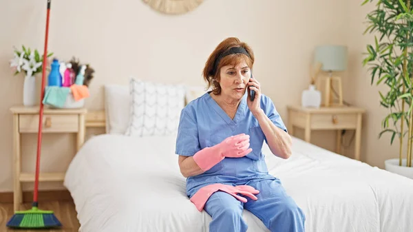 Orta Yaşlı Kadın Profesyonel Temizlikçi Yatak Odasında Akıllı Telefondan Konuşuyor — Stok fotoğraf
