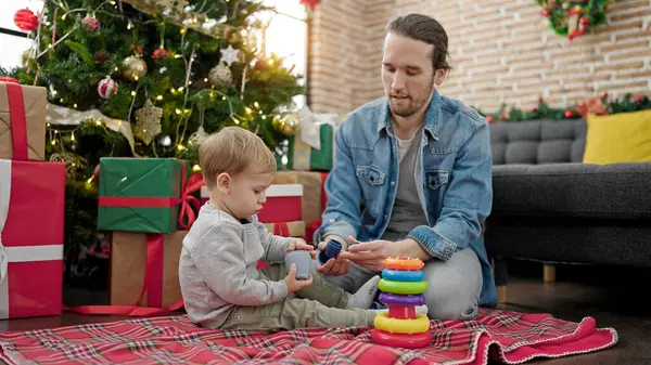 Baba oğul Noel 'i evde oyuncaklarla oynayarak kutluyorlar.