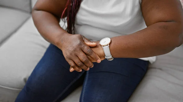 遭受手部疼痛 坐在沙发上 室内生活方式痛苦的非洲裔美国妇女 — 图库照片
