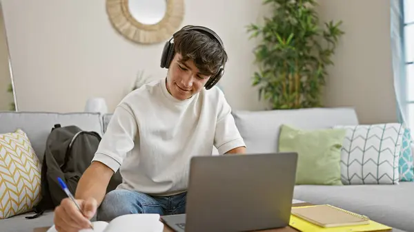 自信的年轻人躺在客厅沙发上 充满热情地从事网上教育 使用笔记本电脑 勤奋地在家里记笔记 — 图库照片