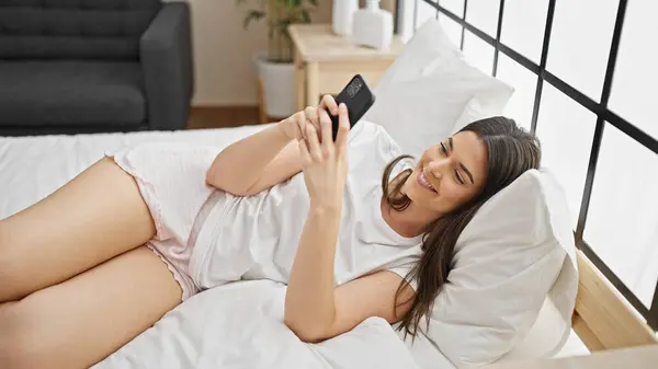 Junge Schöne Hispanische Frau Mit Smartphone Schlafzimmer Liegend — Stockfoto