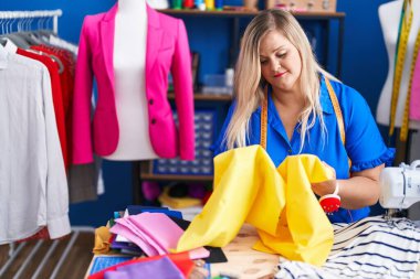 Dikiş atölyesinde dikiş makinesi kullanan genç bir kadın.