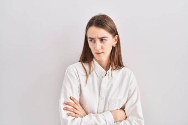 İzole edilmiş arka planda duran beyaz bir kadın şüpheci ve gergin. Yüzünde çapraz kollarla onaylamayan bir ifade var. negatif kişi. 