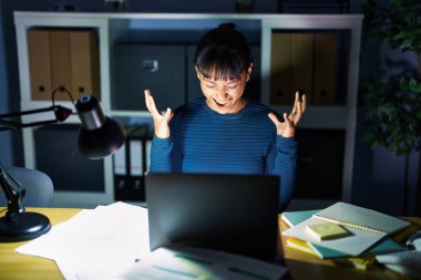 Geceleri ofiste çalışan genç ve güzel bir kadın başarının çılgınlığını kollarını kaldırarak ve gözlerini kapayarak heyecanla bağırarak kutluyor. Kazanan konsept 