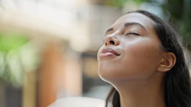 African american woman breathing with closed eyes at street