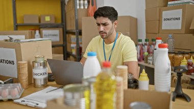 Genç İspanyol gönüllü yardım merkezinde ciddi yüzlü bir laptop kullanıyor.