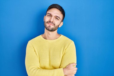 Mavi arka planda dikilen İspanyol adam uykulu ve yorgun görünüyor, yorgunluktan yorgun ve akşamdan kalma, sabahları tembel gözler.. 