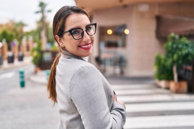 Young beautiful hispanic woman business worker smiling confident standing at street