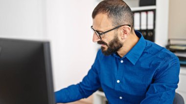 Young hispanic man business worker using computer working at office