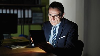 Ofiste dokunmatik ped kullanan orta yaşlı bir iş adamı.