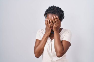 Beyaz arka planda duran Afrikalı kadın. Ağlarken suratını ellerle kapatan üzgün bir ifade. depresyon kavramı. 
