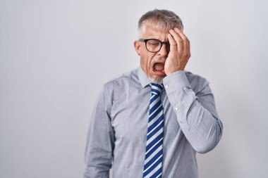 İspanyol iş adamı, gri saçlı, gözlüklü, yarı yüzünü, göz ve ağzını eliyle kapatmaktan yorgun düşmüş. Yüzüm acıyor.. 
