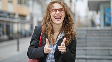 Genç bayan iş adamı kameraya bakıp caddeye gülümsüyor.