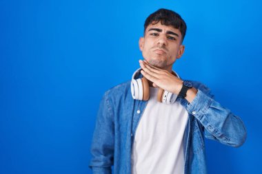 Mavi arka planda dikilen genç İspanyol adam bıçakla boğazı kesiyor, saldırganlığı şiddetle tehdit ediyor. 