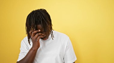 Afrikalı Amerikalı adam, izole edilmiş sarı arka planda durduğunu vurguladı