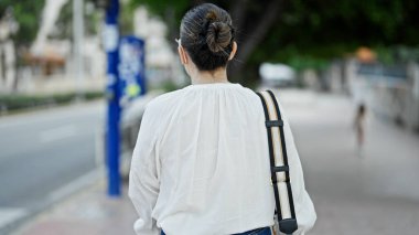 Genç, güzel İspanyol bir kadın sokakta yürüyor.