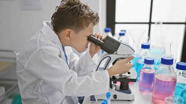 可爱的金发男孩科学家 全神贯注于认真的研究 在一家专业实验室的显微镜前仔细地工作 放大进行更深入的分析 — 图库照片