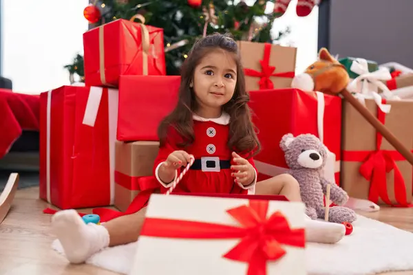 Αξιολάτρευτο Ισπανόφωνο Κορίτσι Ξεπακετάρισμα Δώρο Κάθεται Από Χριστουγεννιάτικο Δέντρο Στο — Φωτογραφία Αρχείου