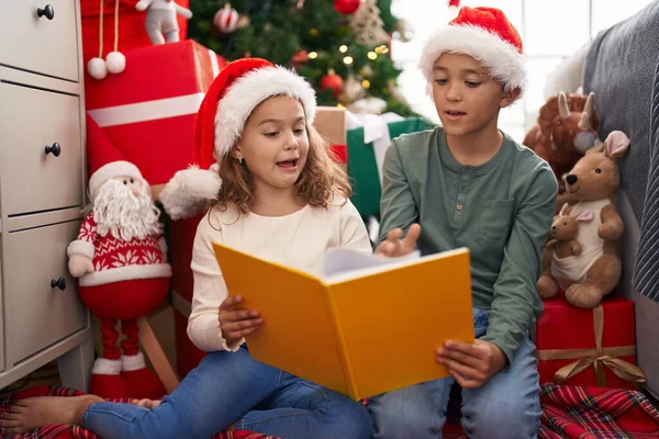 Två Barn Läser Bok Sittandes Golvet Vid Julgran Hemma — Stockfoto
