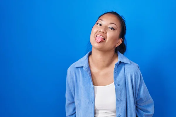 Mujer Joven Asiática Pie Sobre Fondo Azul Sacando Lengua Feliz —  Fotos de Stock