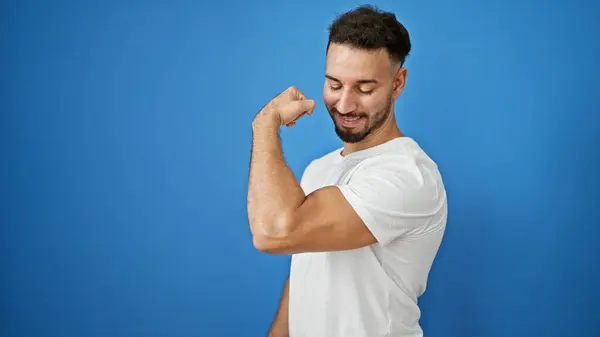 stock image Young arab man smiling confident doing strong gesture with arm over isolated blue background