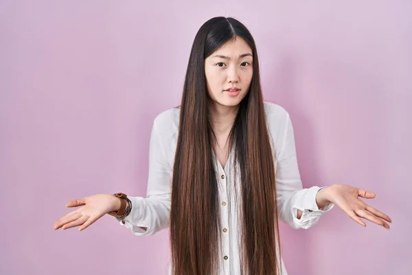 Chinês Jovem Mulher Sobre Fundo Rosa Clueless Confundido Com Braços — Fotografia de Stock
