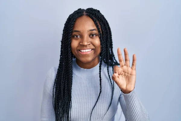 非洲裔美国妇女站在蓝色的背景上 用第三号手指指指指点点 面带微笑 自信而快乐 — 图库照片