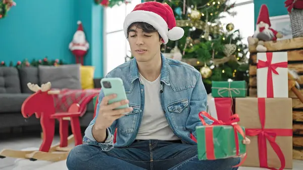Ung Latinamerikan Man Med Smartphone Håller Julklapp Hemma — Stockfoto