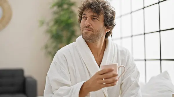 Young Hispanic Man Wearing Bathrobe Drinking Coffee Bedroom — Stock Photo, Image