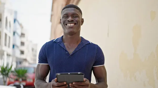 在街上用触摸板自信地微笑的非裔美国人 — 图库照片