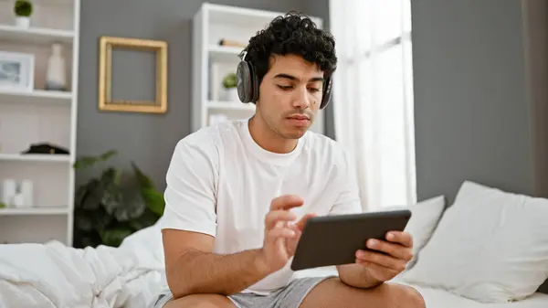 Jonge Latijnse Man Met Behulp Van Touchpad Zitten Het Bed — Stockfoto