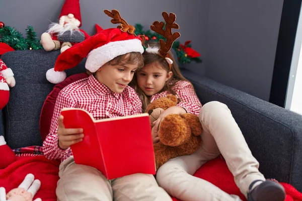 Erkek Kız Kardeş Evde Noel Süsü Olarak Kanepede Kitap Okuyorlar — Stok fotoğraf