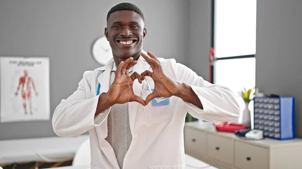 Африканский Американец Доктор Улыбается Делая Сердечный Жест Руками Клинике — стоковое фото