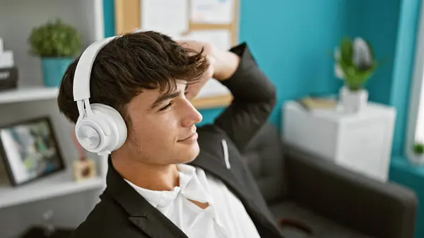 スマイリング スタイリッシュな若いヒスパニック系ティーンエイジャーのビジネスワーカーは 活気に満ちたオフィス環境で働いている間に音楽に振動します — ストック写真