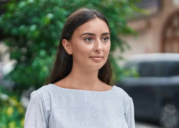 Young beautiful hispanic woman smiling confident looking to the side at street