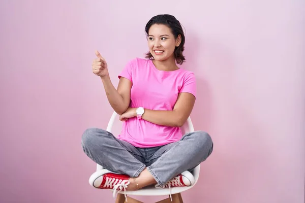 Spaanse Jonge Vrouw Zitten Stoel Roze Achtergrond Kijken Trots Glimlachen — Stockfoto