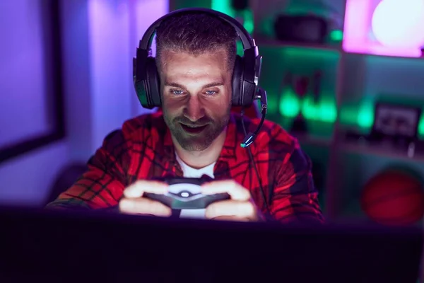 Young caucasian man streamer playing video game using joystick at gaming room