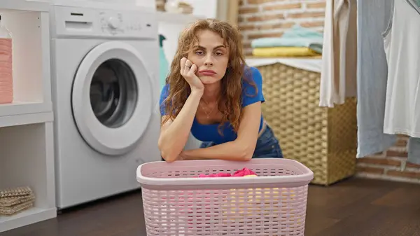 Mladá Žena Drží Oblečení Vyprat Unavený Prádelně — Stock fotografie