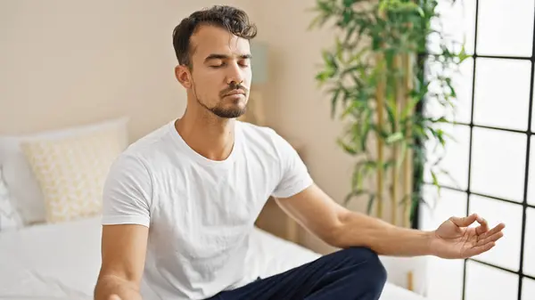 Young Hispanic Man Doing Yoga Exercise Sitting Bed Bedroom — Zdjęcie stockowe