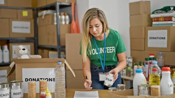 Genç Sarışın Kadın Gönüllü Olarak Yardım Merkezindeki Ürünleri Kontrol Ediyor — Stok fotoğraf