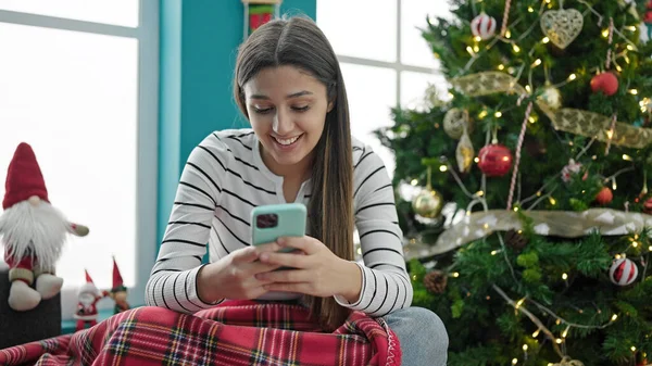 Νέα Όμορφη Ισπανόφωνη Γυναίκα Χρησιμοποιώντας Smartphone Γιορτάζει Χριστούγεννα Στο Σπίτι — Φωτογραφία Αρχείου