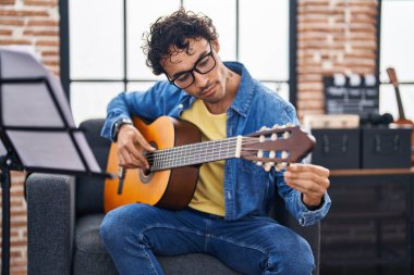 Genç İspanyol müzisyen müzik stüdyosunda klasik gitar çalıyor.