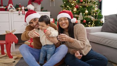 Bir çift ve oğlu balo düzenliyor. Evdeki Noel ağacının yanında oturuyorlar.