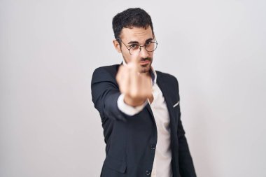Handsome business hispanic man standing over white background showing middle finger, impolite and rude fuck off expression 