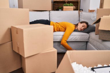 Beyaz bir kadın kanepeye uzanmış, yeni evinde uyuyor.