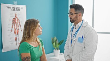 Kadın ve erkek doktor klinikteki hastalarla tıbbi danışmanlık yapıyorlar.